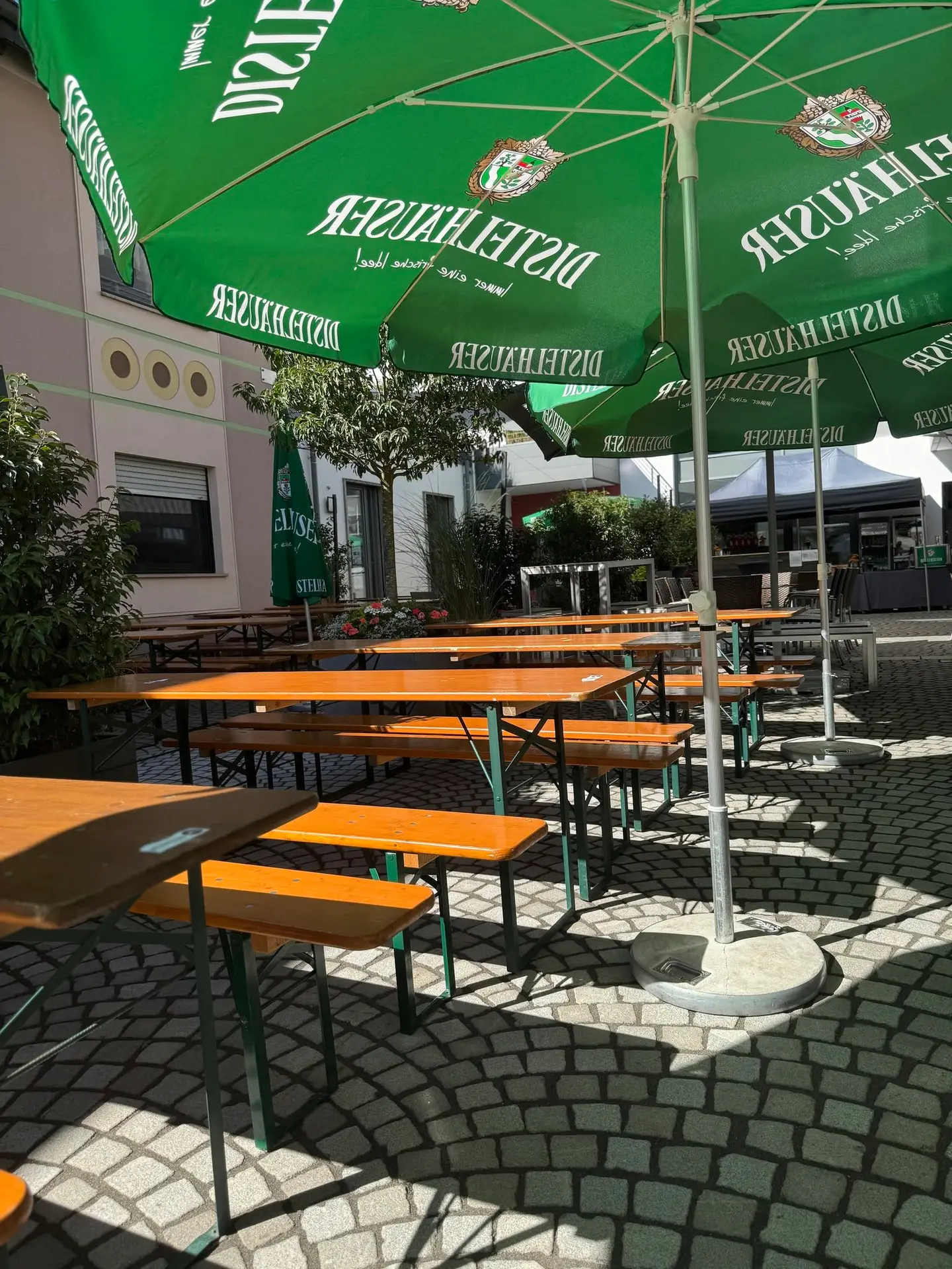 Biergarnituren unter Distelhäuser-Sonnenschirmen beim Schoppenfest im Libero53