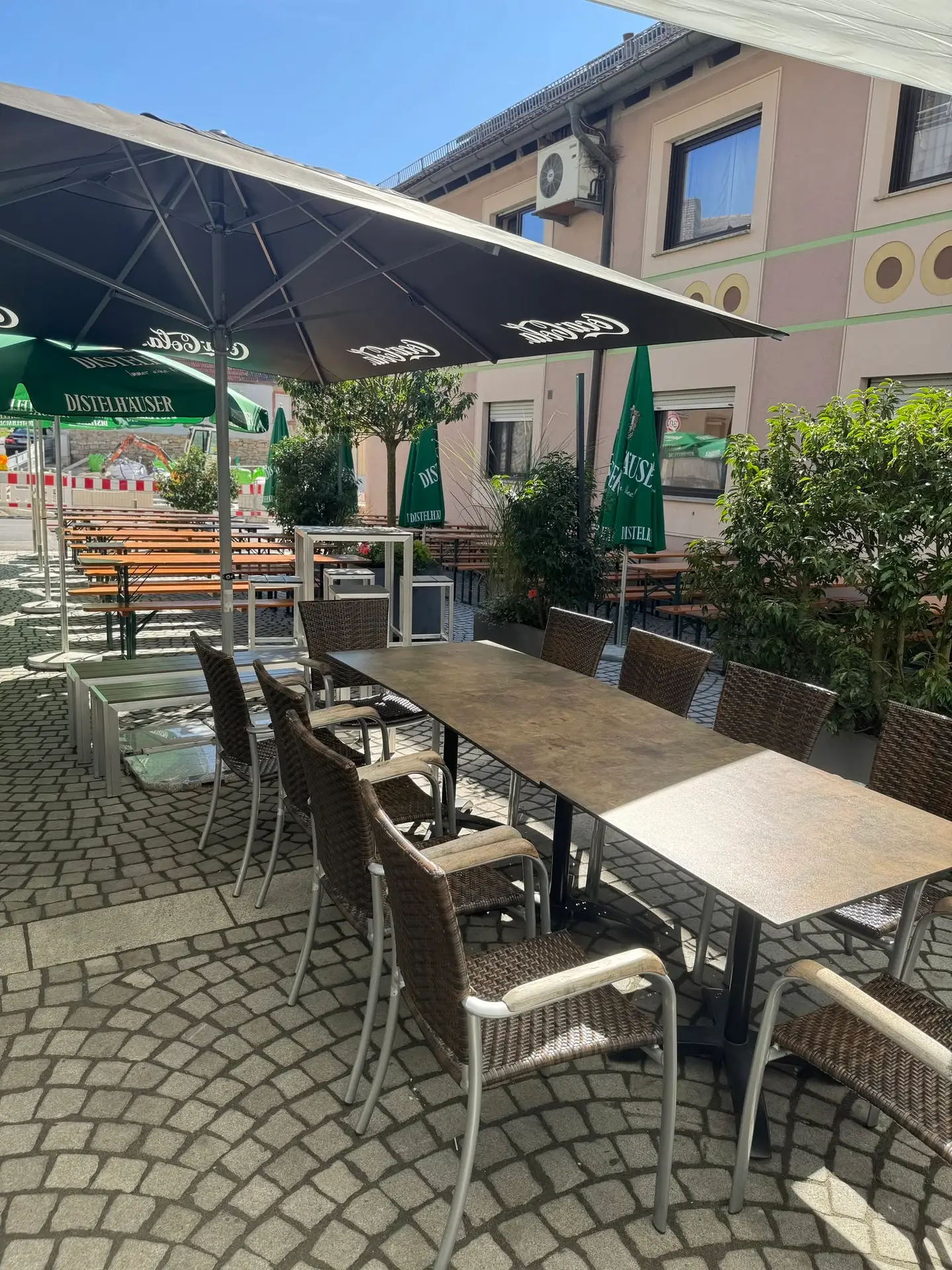 Terrasse mit Sitzplätzen und Distelhäuser-Sonnenschirmen beim Schoppenfest im Libero53